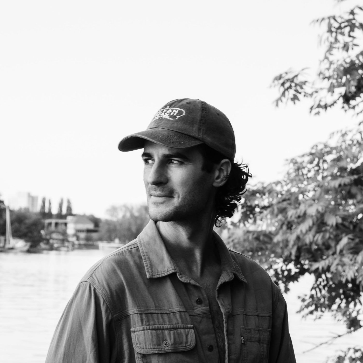 Ben Camden, in a cap and work shirt, by the water